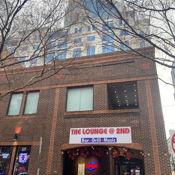 The Lounge @ 2nd bar-and-grill building exterior with a banner sign and festive wreaths.